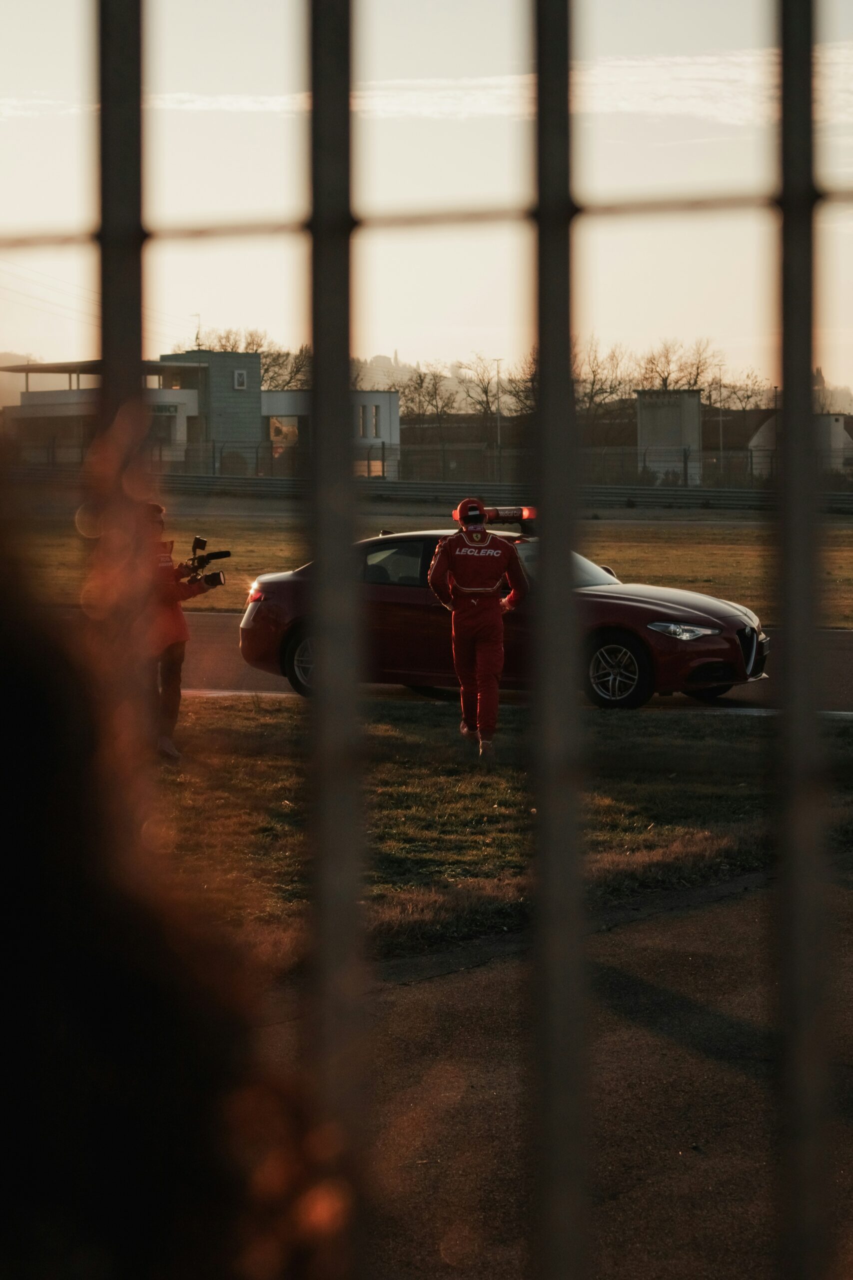 a person in a red suit standing next to a red car