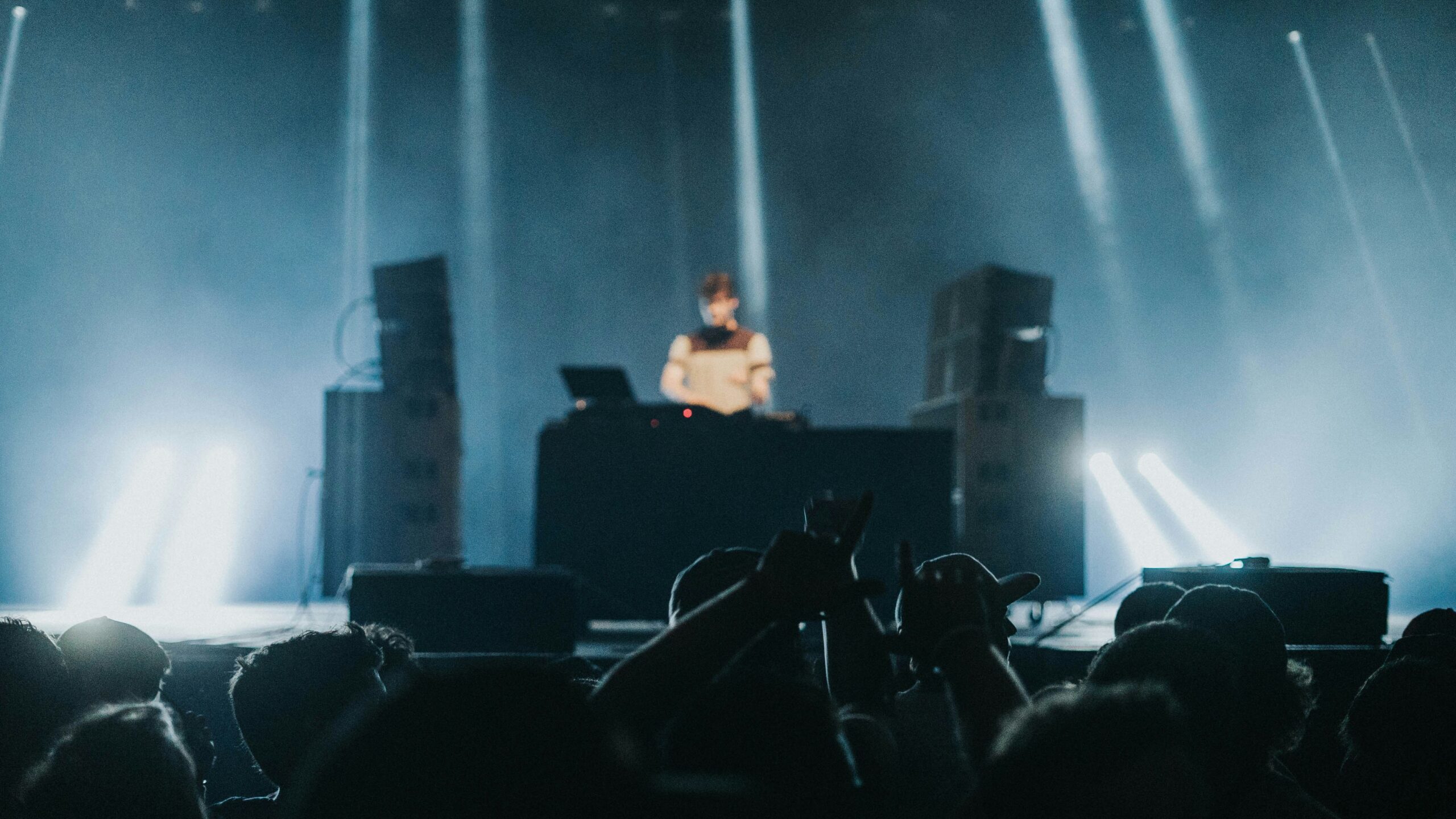 man standing playing audio mixer and DJ mixer on stage