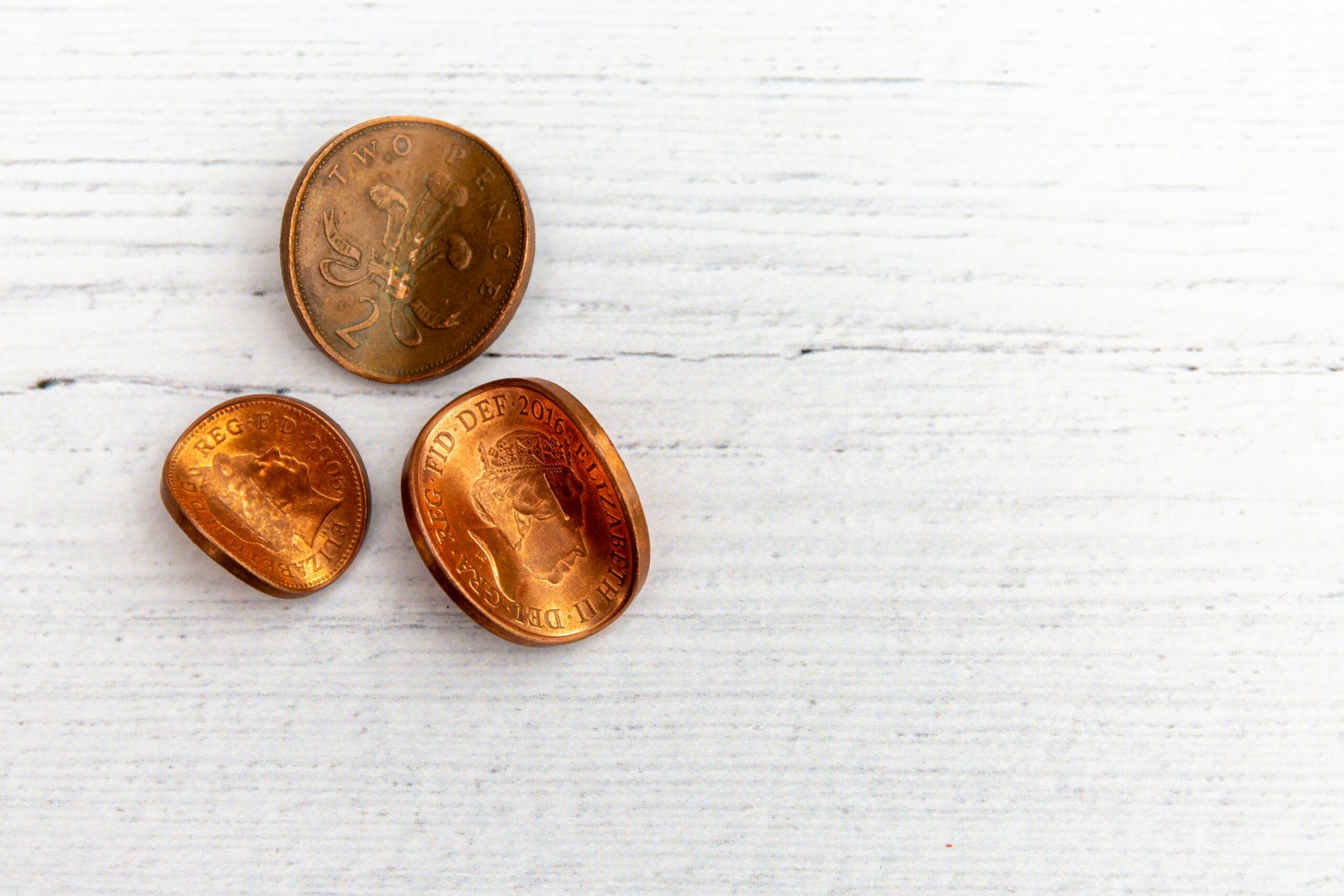 2 silver round coins on white wooden table