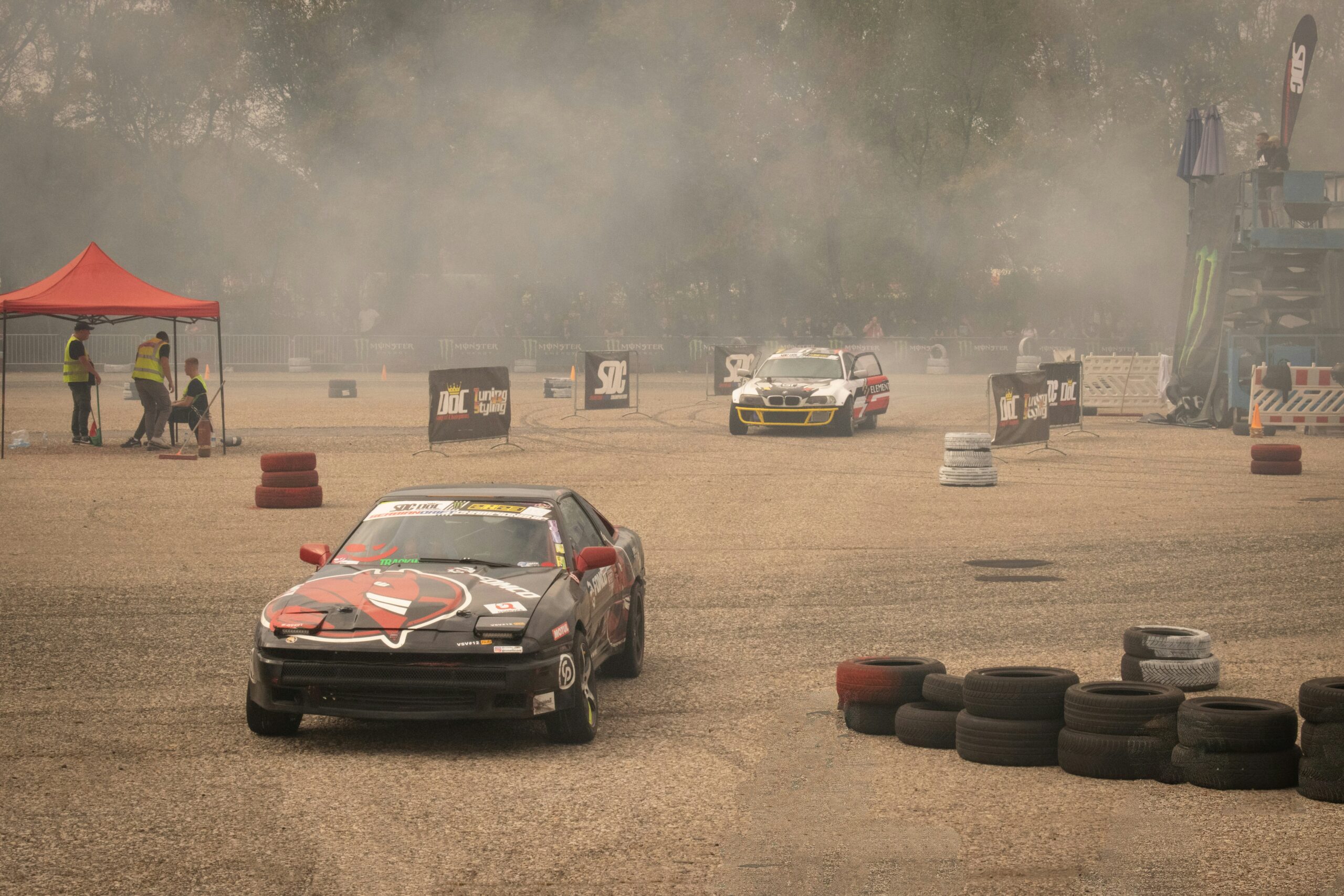 a car driving around a track with smoke coming out of it