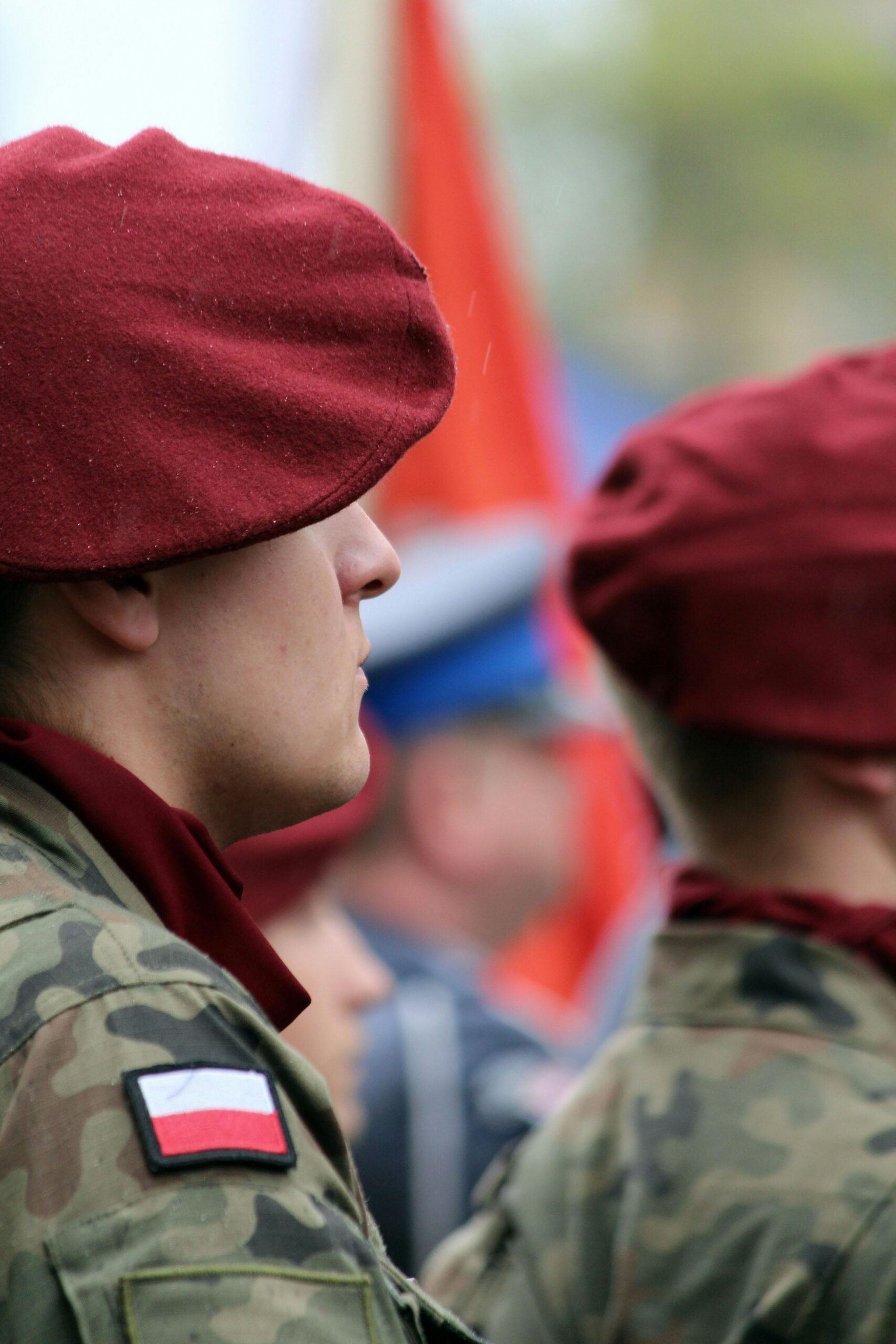 a man in a red beret standing next to another man