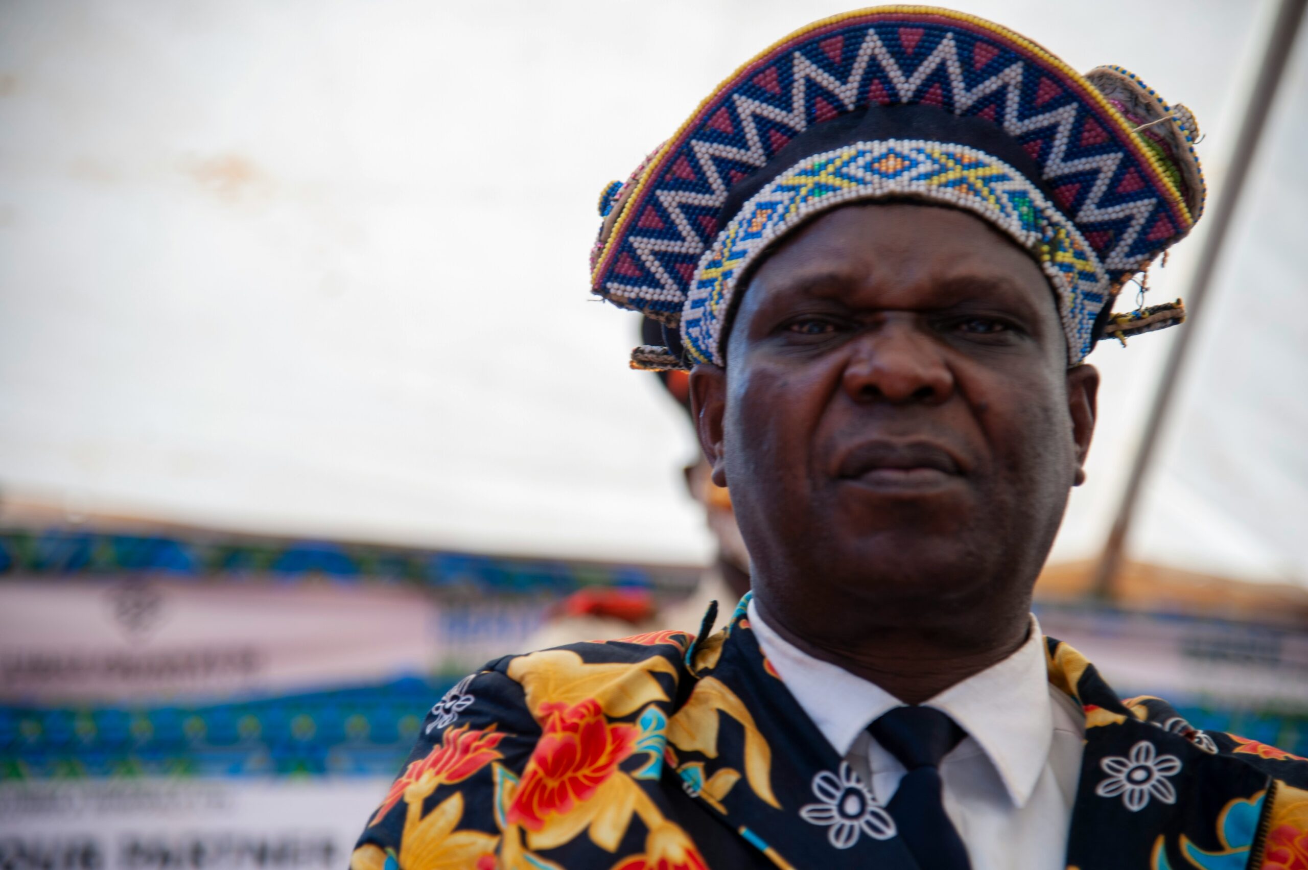 a man wearing a colorful head piece and a tie