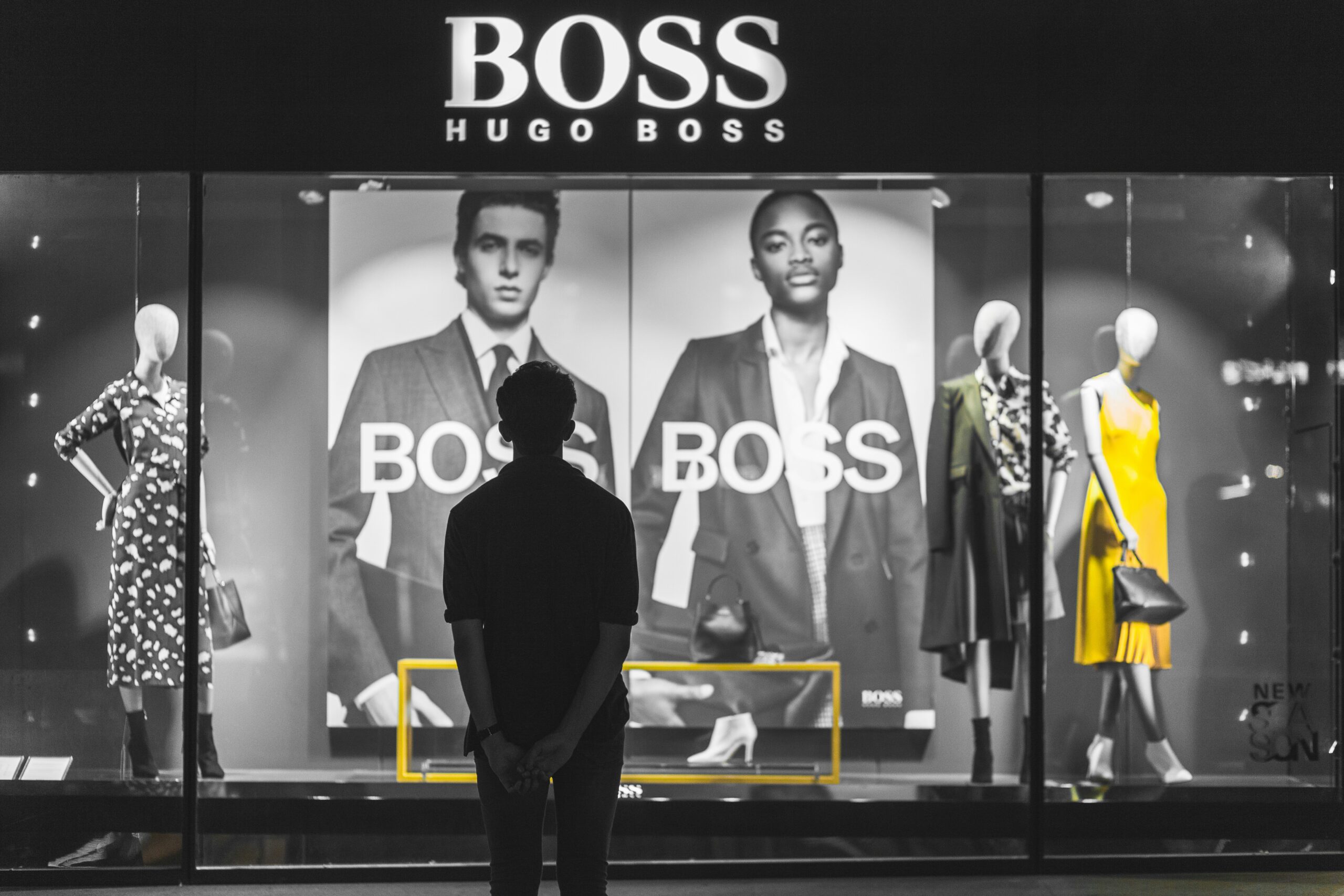 man standing in front of Boss Hugo Boss store