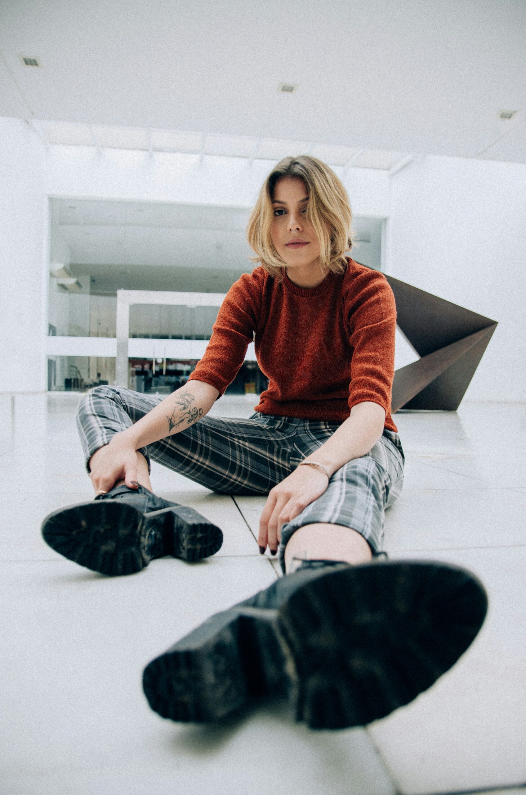 woman sitting on floor tiles inside building