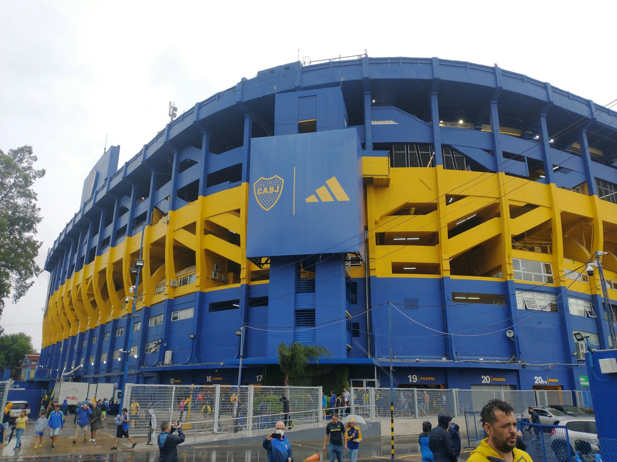 A group of people standing in front of a blue and yellow building