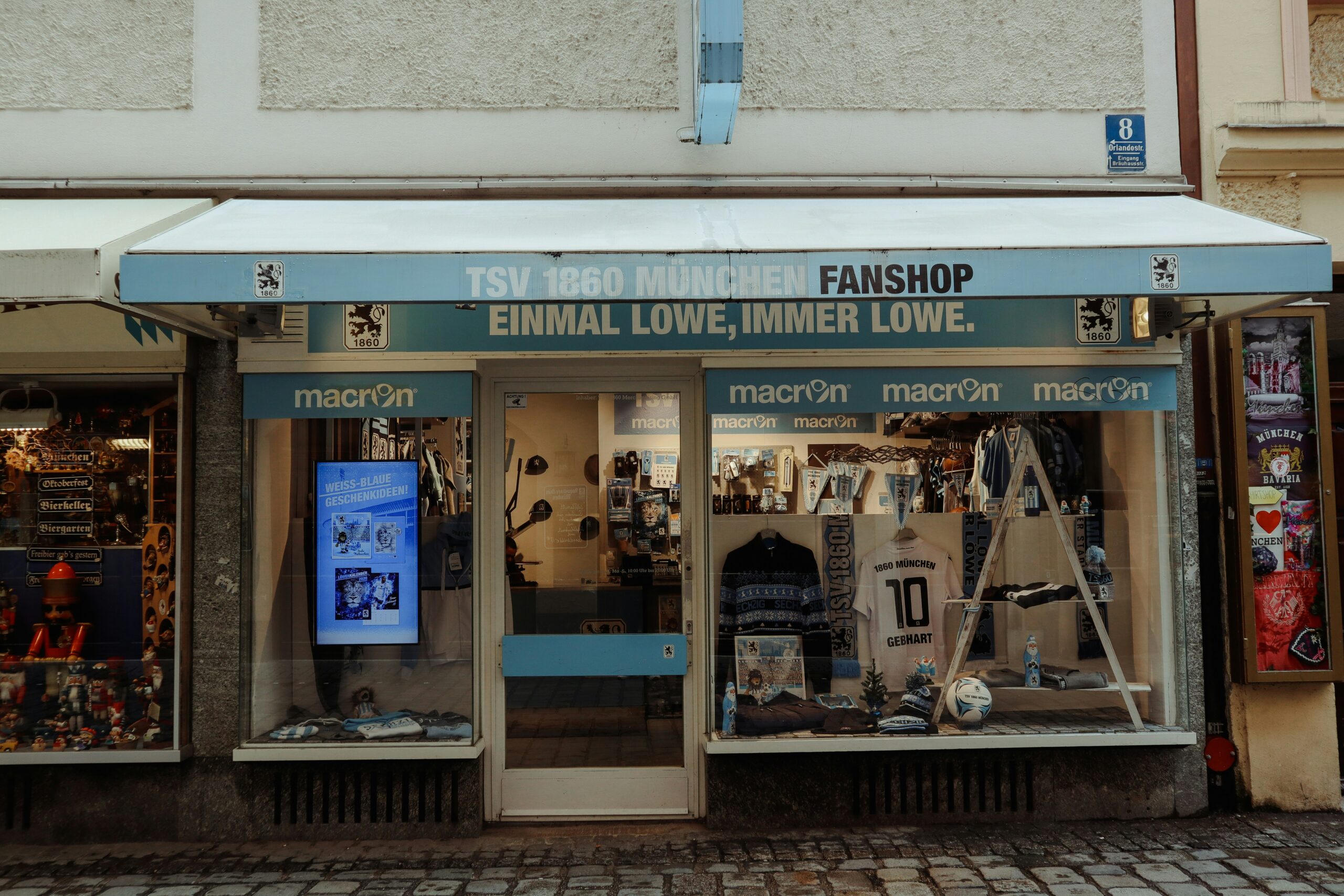 a store front with a white awning and a blue and white awning