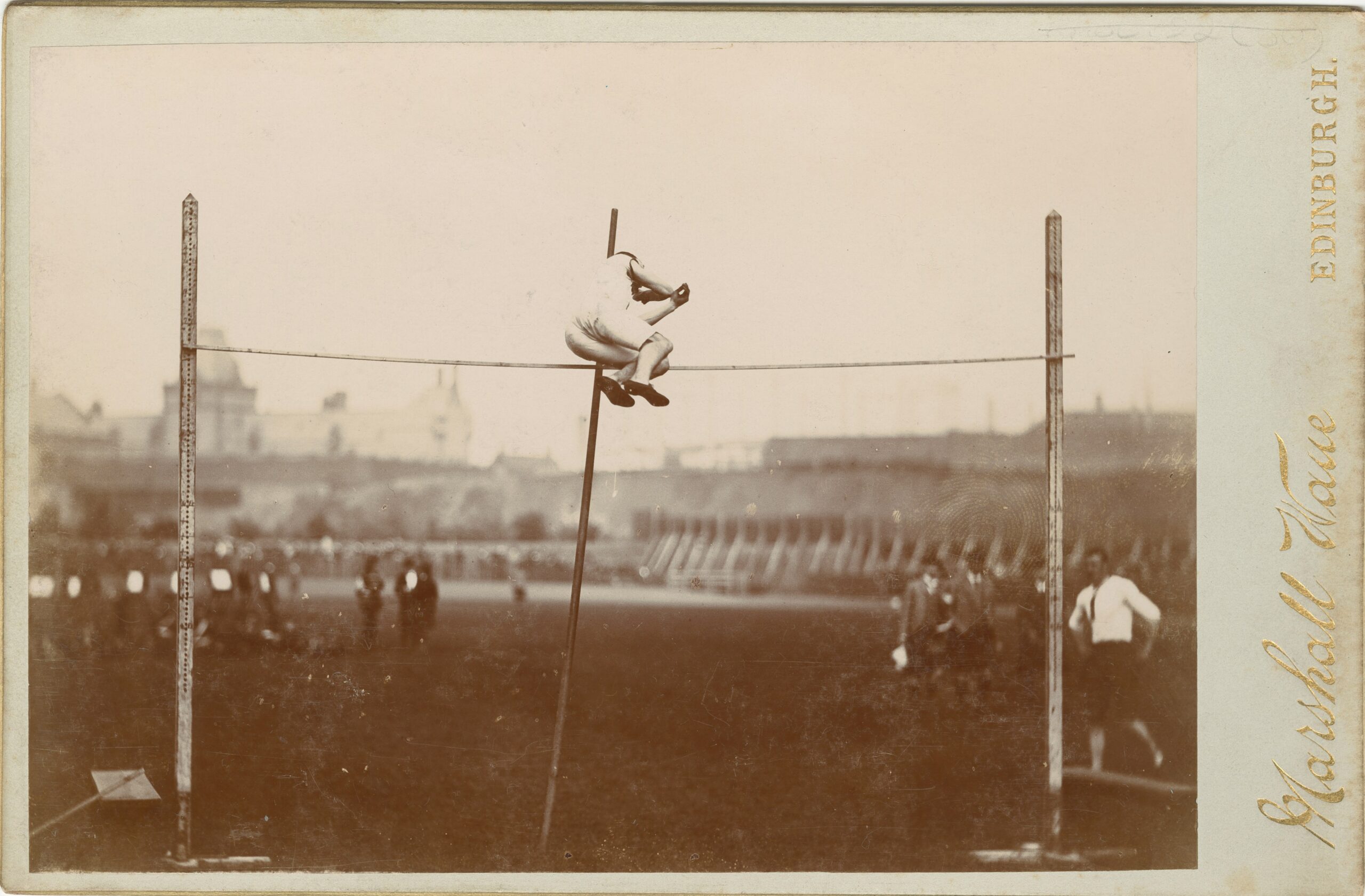 an old photo of a man on a high jump