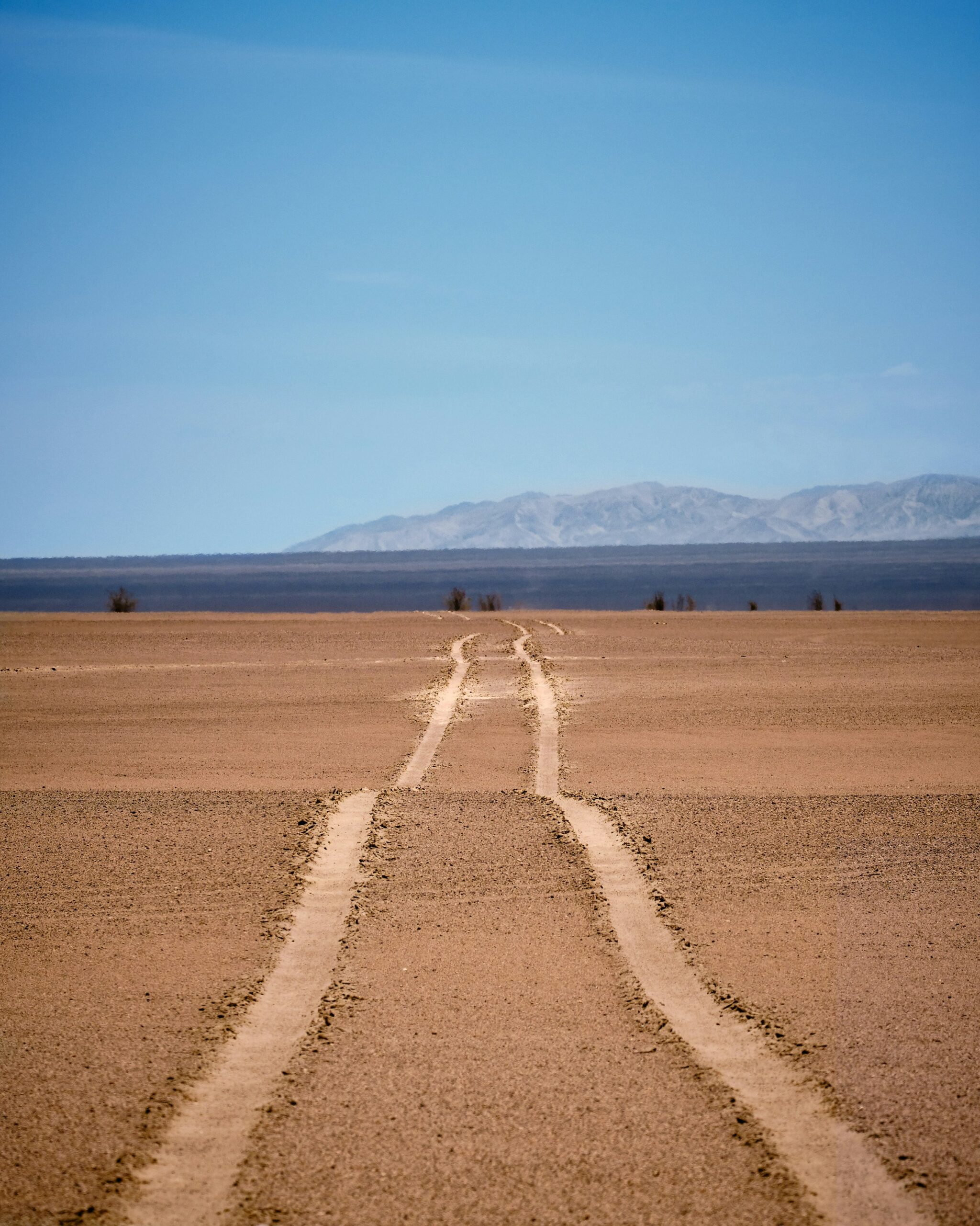 brown sand field under blue sky during daytime