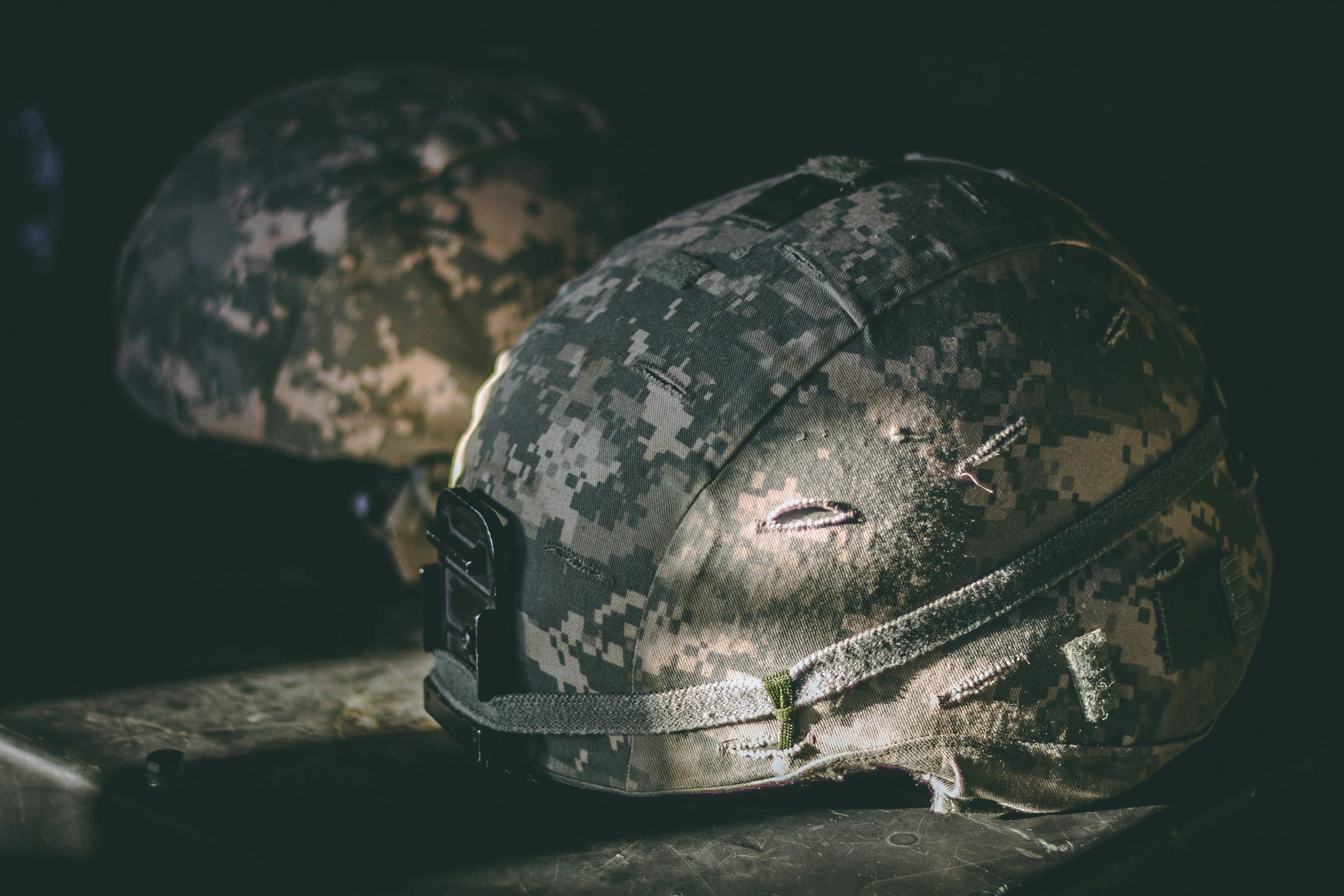 gray and brown camouflage nutshell helmet on table