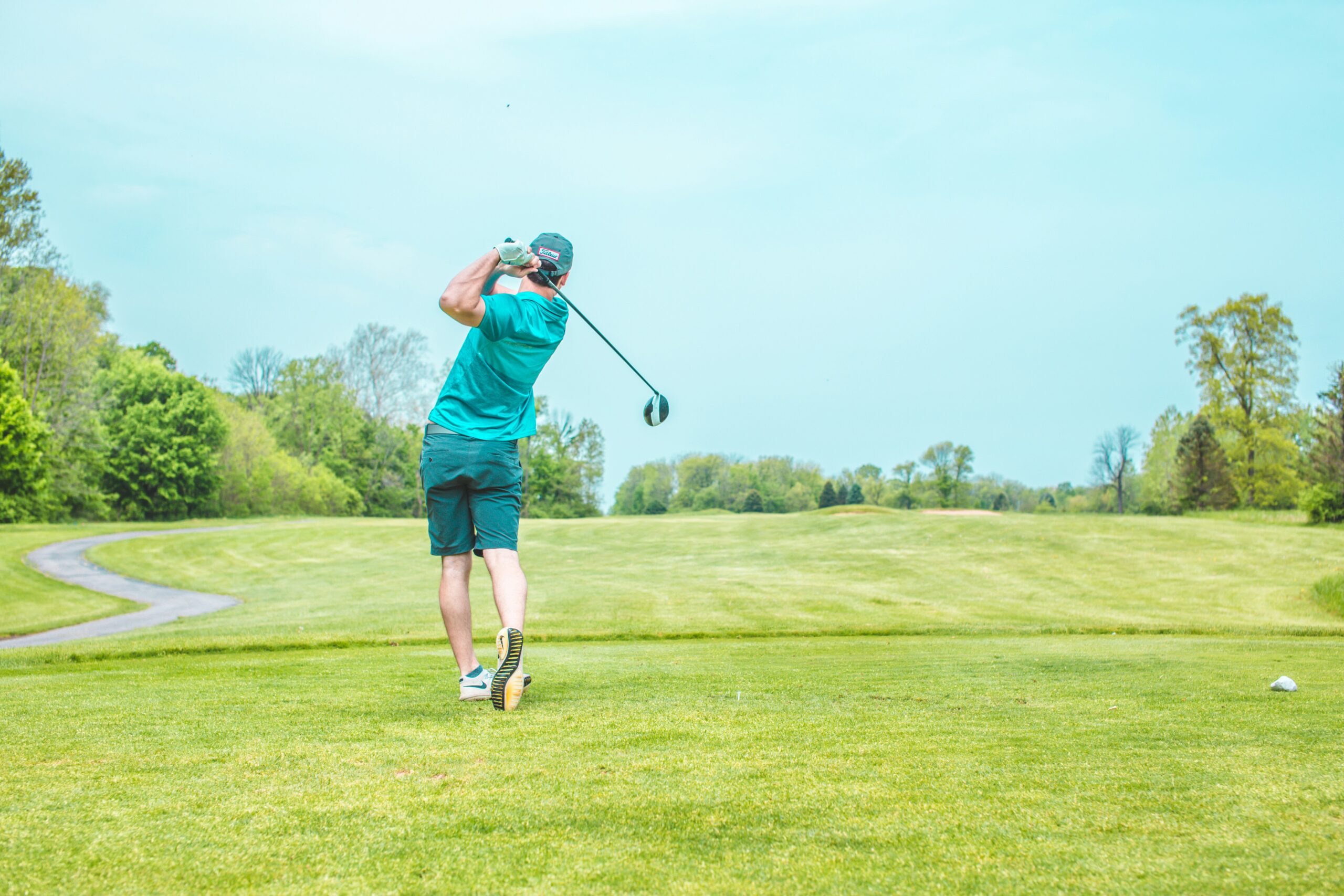 man playing gold under blue sky during daytime