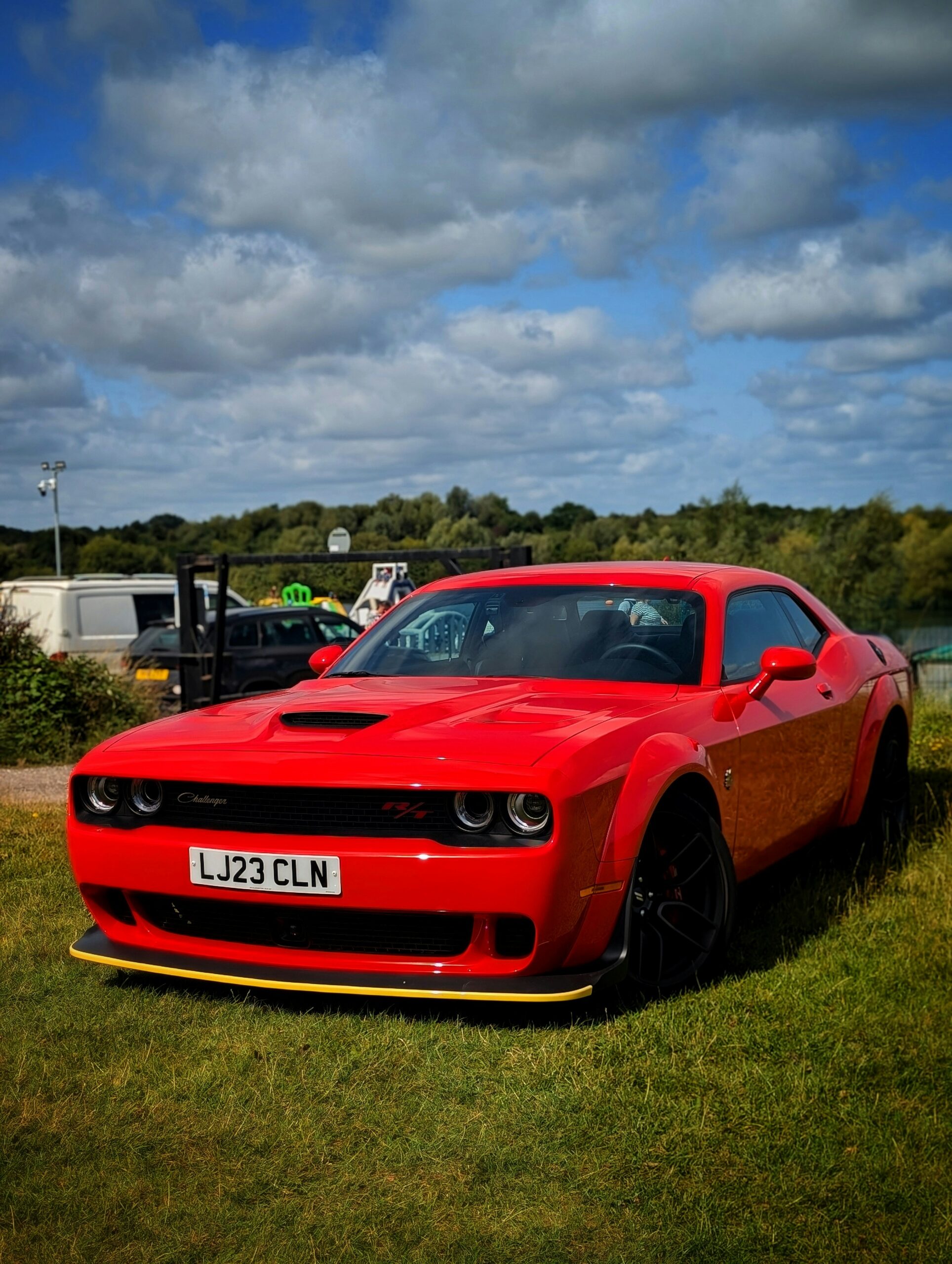 A red sports car parked in a grassy field