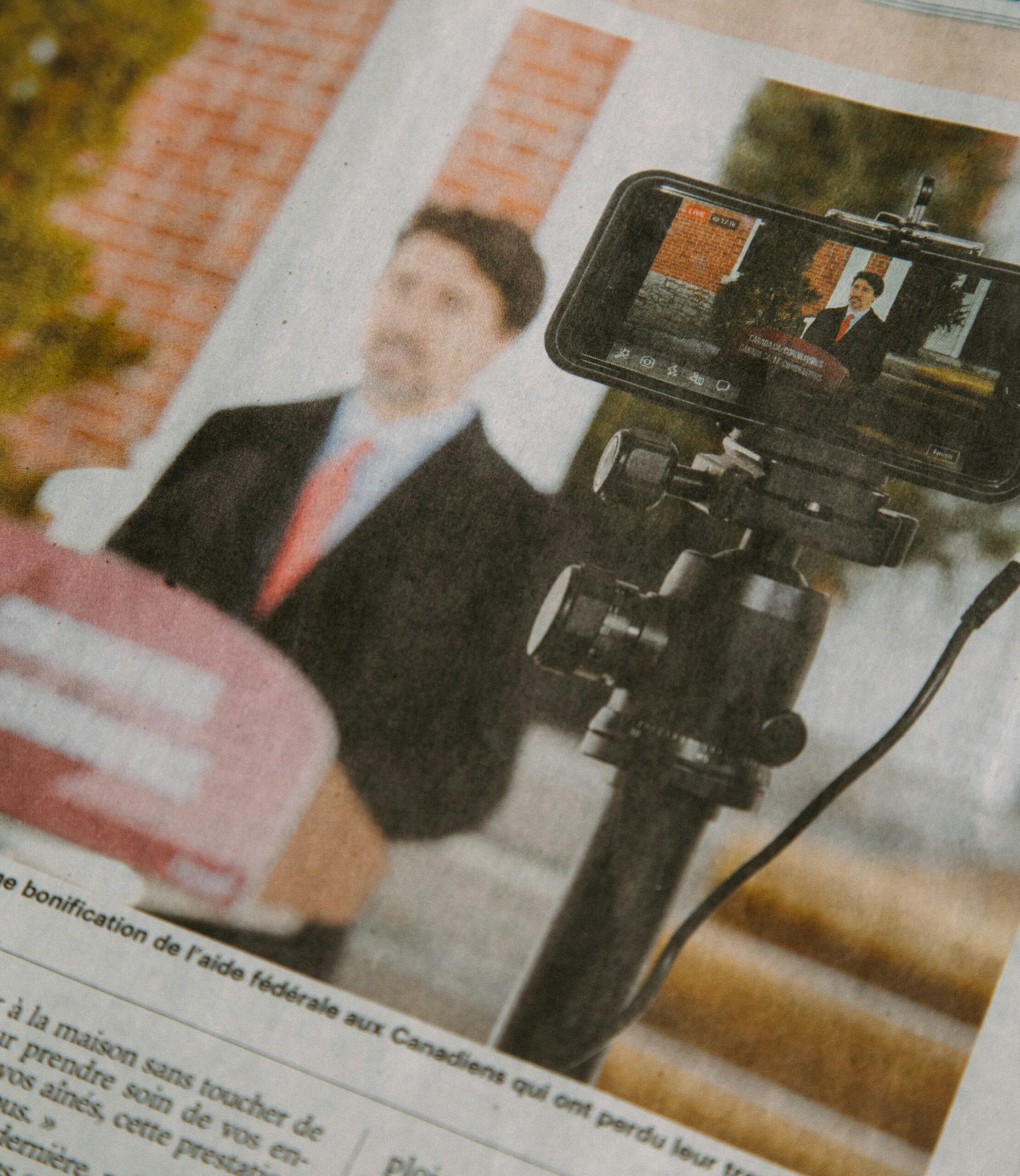 man in black suit jacket holding black camera